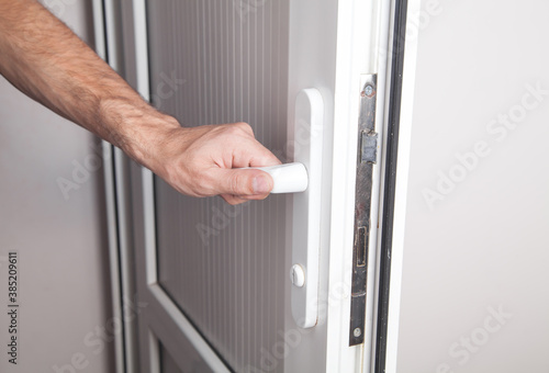 Male hand opening a door in home.