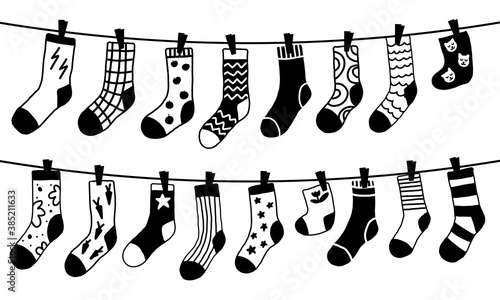 Doodle black and white socks on the rope. Winter trendy clothing items with different texture and color. 