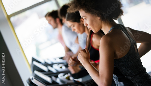 Fit woman working out in a treadmill at the gym and smiling