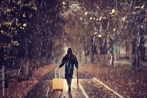 Canvas Print night the girl is walking with an umbrella and a suitcase in the autumn park, th
