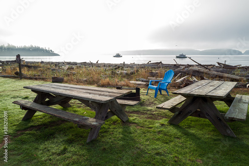 Picnic tables and blue chair at Spencer Spit State Park on Lopez Island, Washington, USA