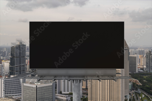 Blank black road billboard with Singapore cityscape background at sunset. Street advertising poster, mock up, 3D rendering. Front view. The concept of marketing communication to sell idea.