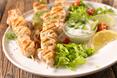 grilled chicken skewer with sauce and lettuce