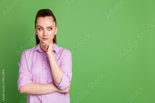 Photo of minded smart girl touch hand chin look copyspace think thoughts decision choice wear violet shirt isolated over green color background