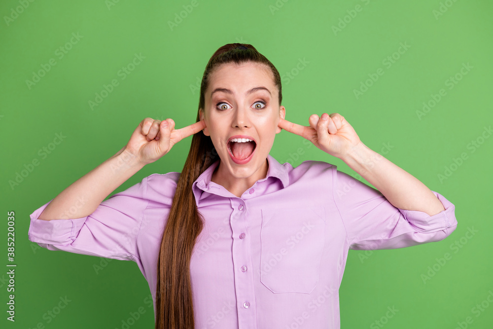 Photo of astonished girl close cover ears index finger shout impressed wear violet outfit isolated over green color background Photo of astonished girl close cover ears index finger shout impressed wear violet outfit isolated over green color background