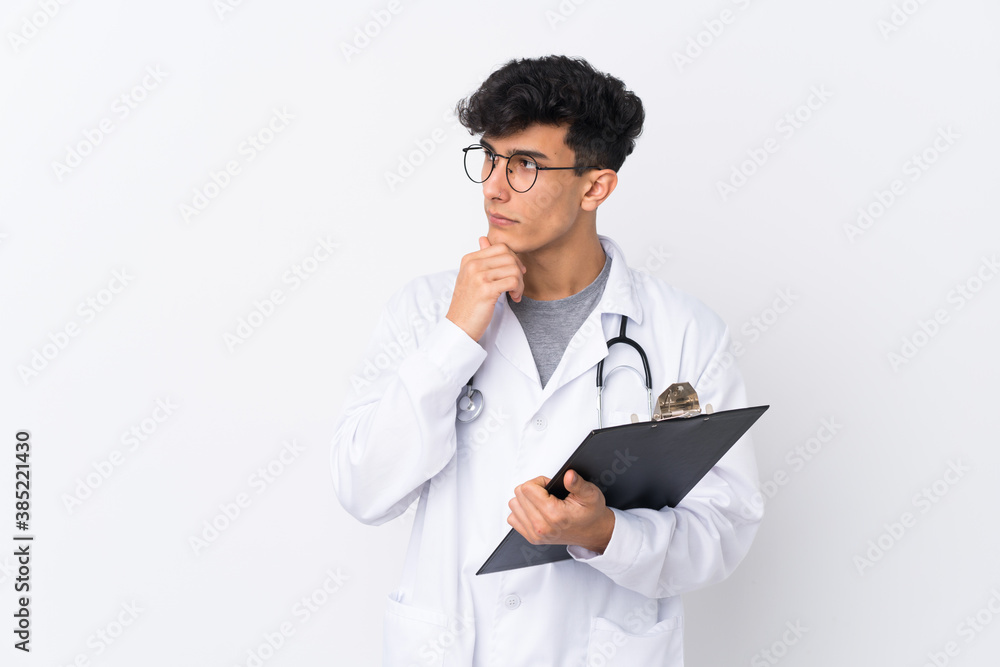 Young Argentinian man over isolated white background wearing a doctor gown and holding a folder