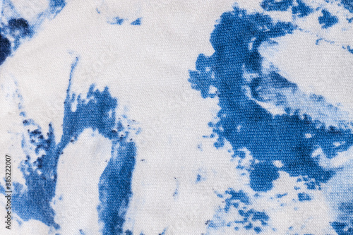 Tie-dye cotton fabric texture blue and white paint colors. Ancient resist-dyeing textile coloring technique, saturated primary colors, bold patterns, simple motifs, monochromatic color schemes garment photo