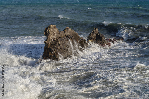 Splashing waves against rocks. Ligurian sea. Italy
