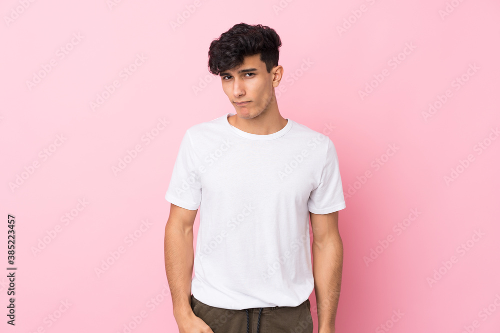 Young Argentinian man over isolated pink background sad Young Argentinian man over isolated pink background sad