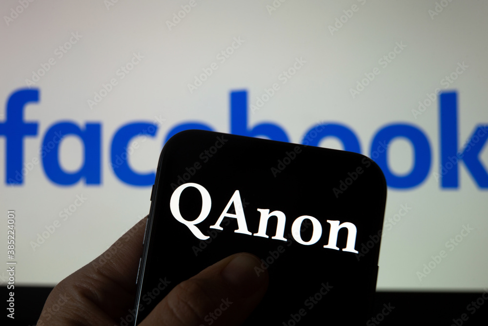 QAnon vs FACEBOOK. QAnon organization logo seen on the smartphone which ...