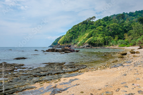 Beautiful sea tropical landscape. Rocky coast and sandy beach. Green hills covered with rainforest. Koh Lanta, Thailand