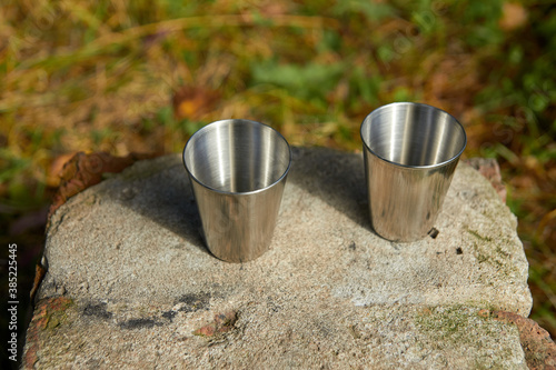 Metal cups for strong alcohol stand on a stone.