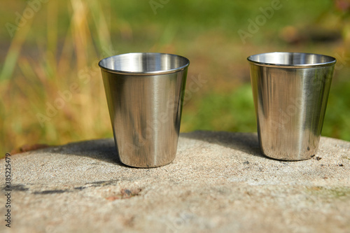 Metal cups for strong alcohol stand on a stone.