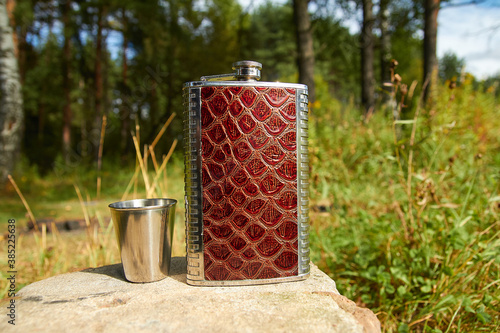 Metal flask with measuring cups. A flask for alcohol.