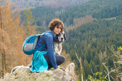 Young woman with English Setter dog hiking in the mountains