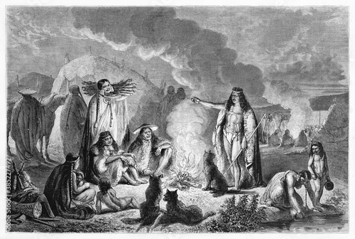 Teuelche people tribe around fire in their camp at evening, Patagonia. Ancient grey tone etching style art by Hadamard, published on Le Tour du Monde, Paris, 1861 photo