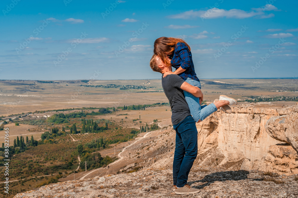 Romantic couple on the edge of a cliff on a White rock in the Crimea, a man picked up a woman Romantic couple on the edge of a cliff on a White rock in the Crimea, a man picked up a woman