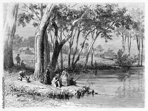 People angling under shade of trees on river shore in Victoria region, Australia. Ancient grey tone etching style art by Girardet, Le Tour du Monde, Paris, 1861 photo