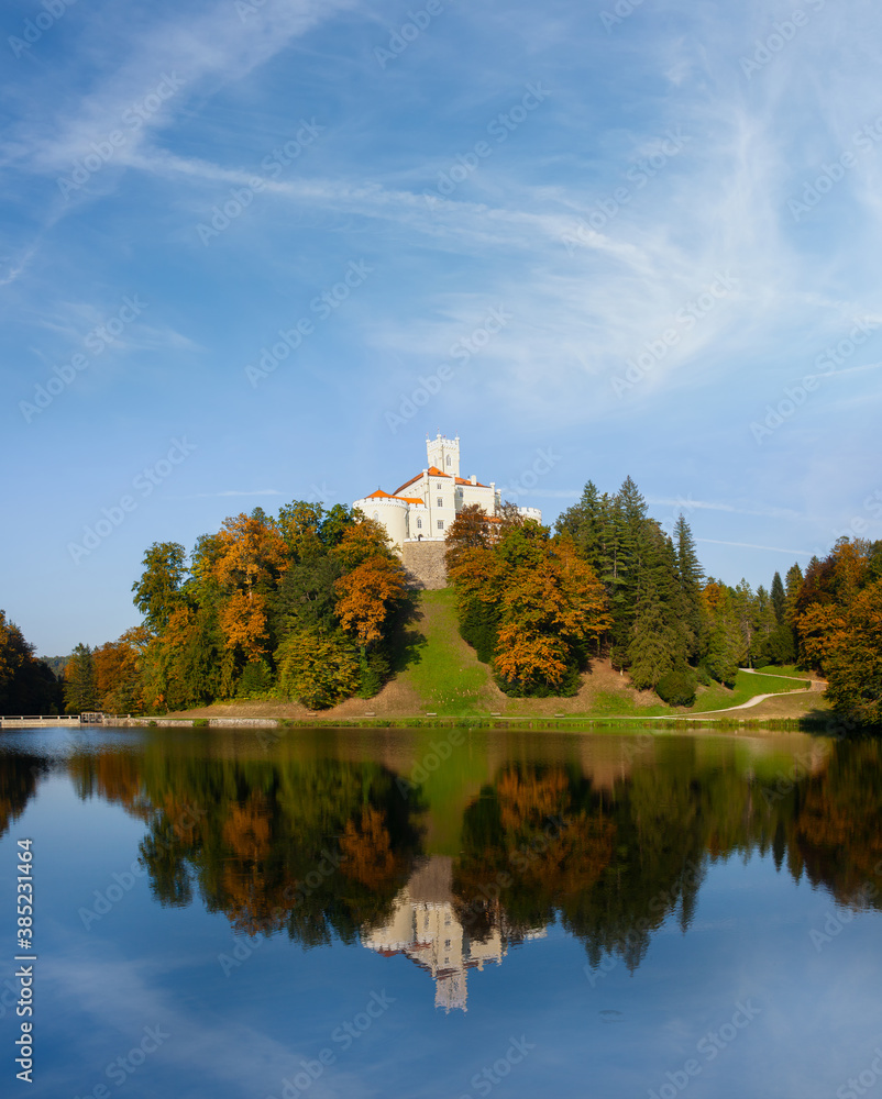 Castle Trakoscan on top of the hill, reflection of castle and blue sky in the lake, autumn foliage Castle Trakoscan on top of the hill, reflection of castle and blue sky in the lake, autumn foliage