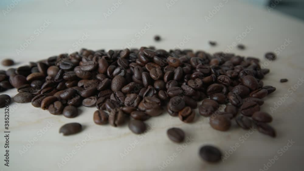 Detail view of coffee beans scattered on wooden table Detail view of coffee beans scattered on wooden table
