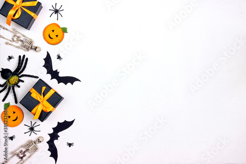 Border from Halloween holiday decorations and gifts on white background.