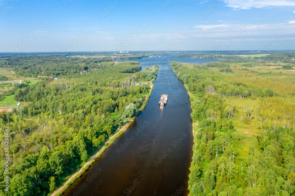 Fototapeta premium Top view of a water channel and a moving barge