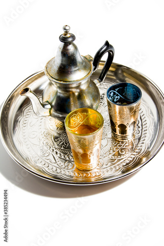 Group of teapot and glasses of oriental tea on a tray on white background