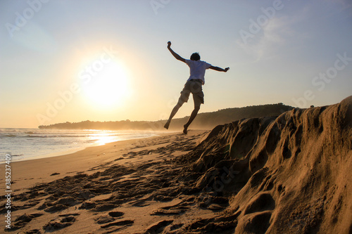 Silhouette of a boy jumping celebrating the sunset. 