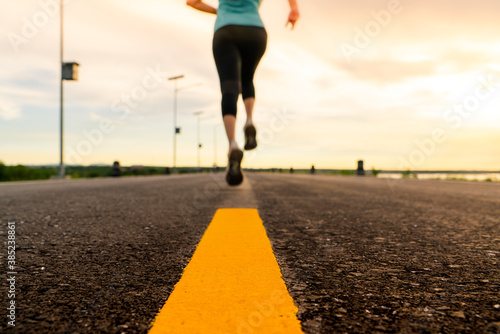Athlete running on the road trail in sunset training for marathon and fitness. motion blur of woman exercising outdoors