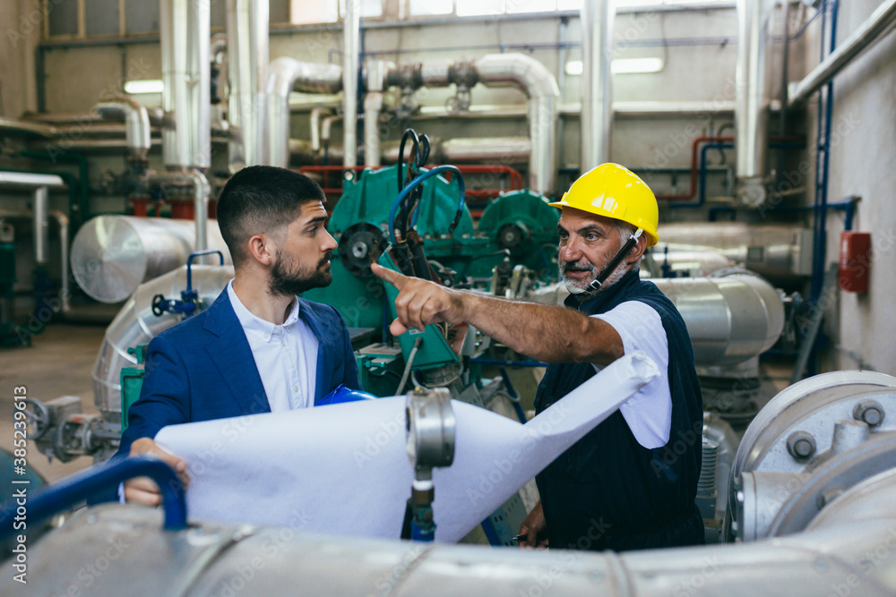 industrial workers looking at the blueprints industrial workers looking at the blueprints