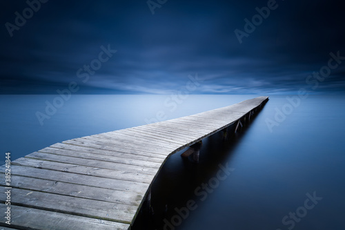 Dark blue atmosphere around a pier to the lake of Sanguinet photo