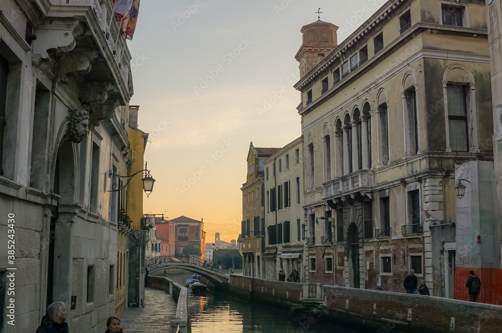 Venice, Italy - 23/01/18
Warm sunset sky in the water of city, Venice.
Many people and ancient buildings, calm sea.