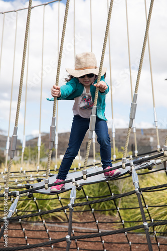 Children playing on a rope climbing gym at an outdoor park on a bright day