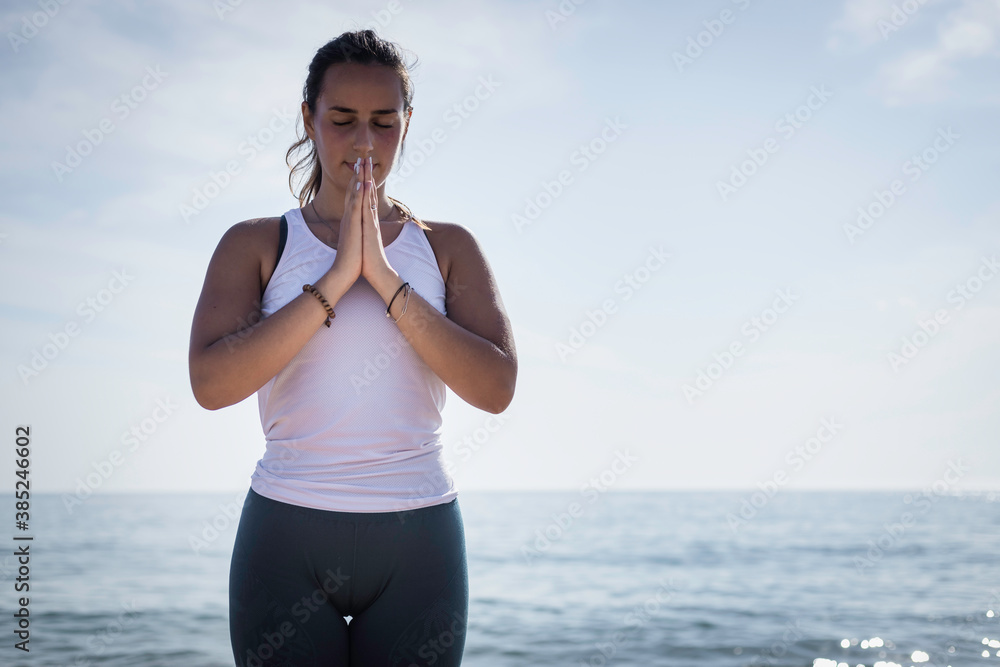 Sporty young woman doing Yoga exercises using a gym mat along the beach in Lisbon, Portugal. Playful woman working as freelance Yoga teacher doing fitness workout on the beach at sunset. Healthy life Sporty young woman doing Yoga exercises using a gym mat along the beach in Lisbon, Portugal. Playful woman working as freelance Yoga teacher doing fitness workout on the beach at sunset. Healthy life