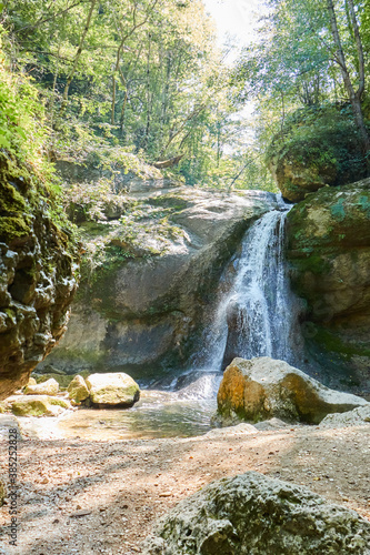 Mountain waterfall in the forest, a large noisy stream of water photo