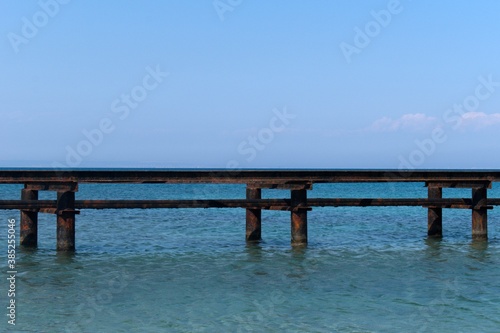 old rusty base of sea marina against the backdrop of endless sea horizon © Irik