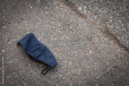 Used face mask on the asphalt.