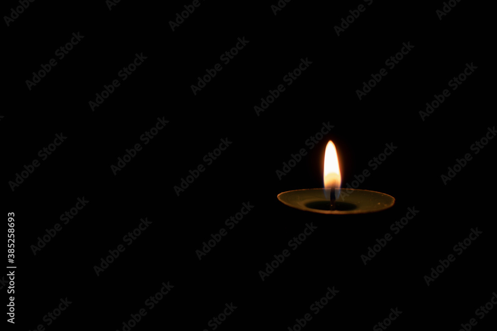 small burning candle on a dark background small burning candle on a dark background