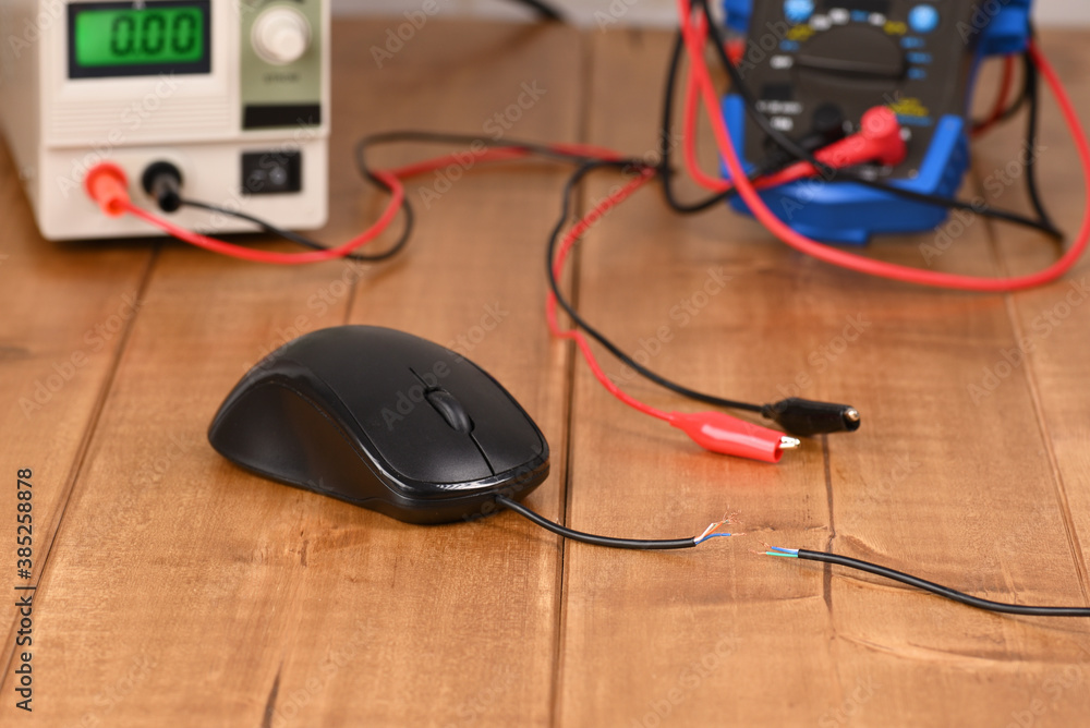 Broken mouse cord against the background of electronic measuring devices. Broken mouse cord against the background of electronic measuring devices.