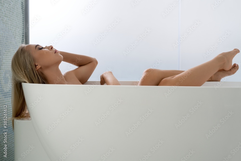 Obraz premium Sensual young woman relaxing in bathtub in bathroom