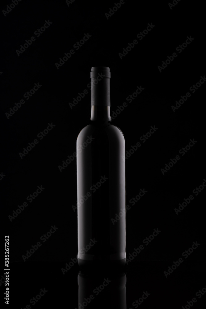 Wine bottle silhouette isolated on dark background. Mockup of bottle on dark backdrop. Studio photography. Wine bottle silhouette isolated on dark background. Mockup of bottle on dark backdrop. Studio photography.