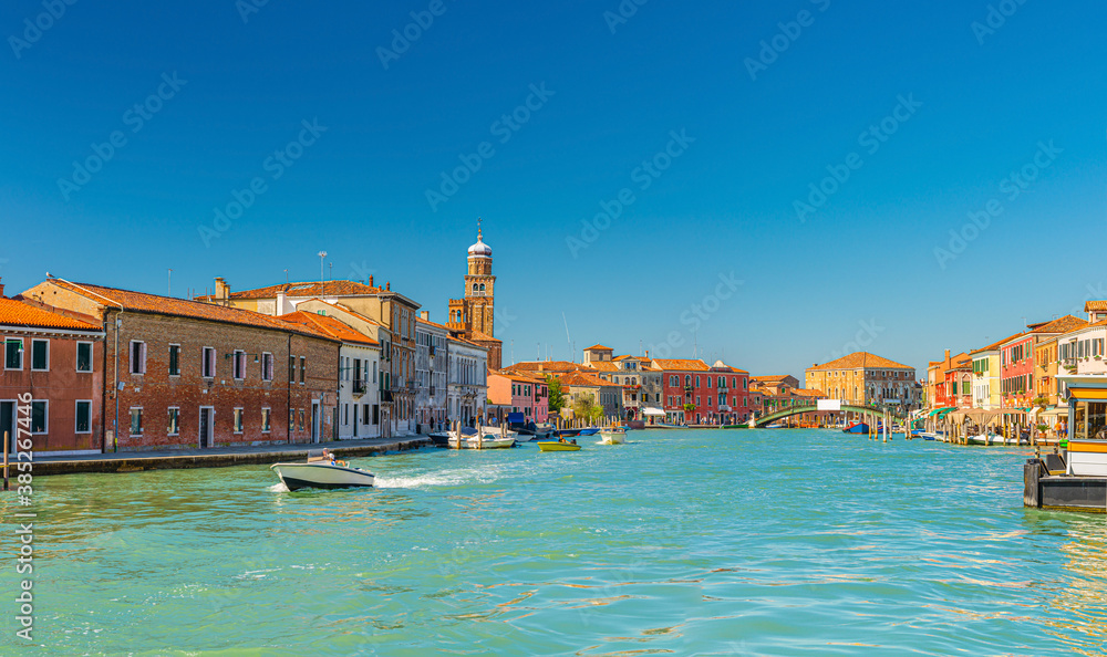 Obraz premium Murano islands with bridge across water canal, boats and motor boats, colorful traditional buildings, Venetian Lagoon, Province of Venice, Veneto Region, Northern Italy. Murano postcard cityscape.