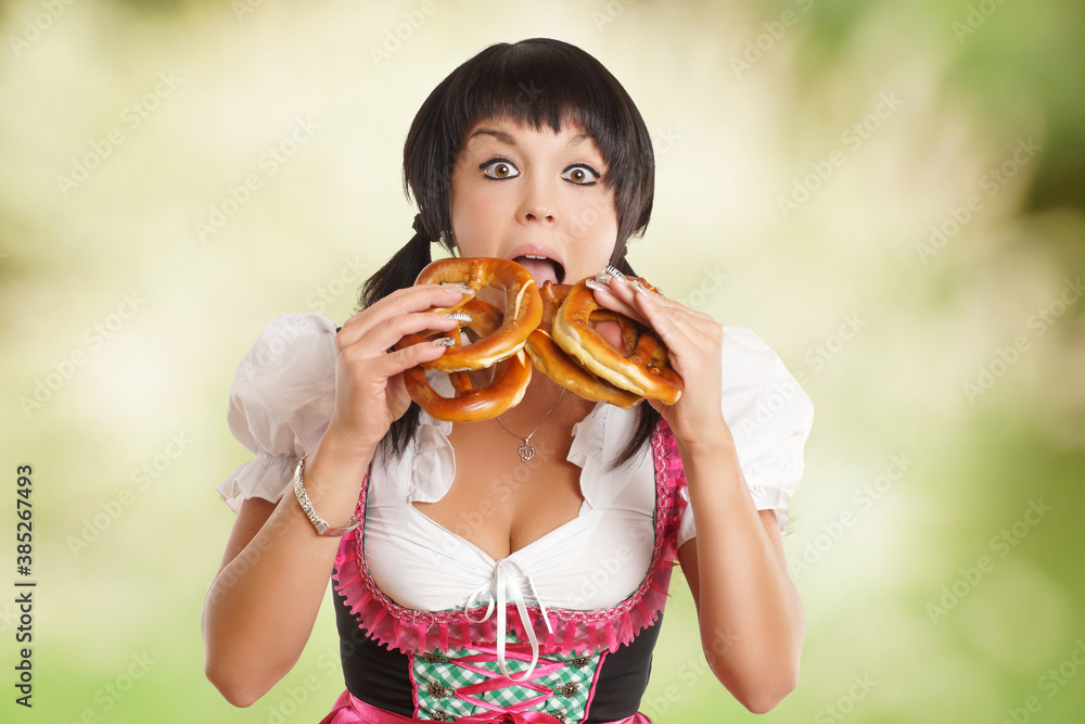 Frau im Dirndl beim Brezel essen Frau im Dirndl beim Brezel essen