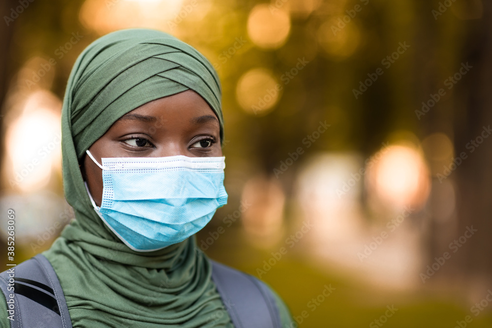 Closeup Portrait Of Black Muslim Lady In Hijab Wearing Medical Mask Outdoors Closeup Portrait Of Black Muslim Lady In Hijab Wearing Medical Mask Outdoors