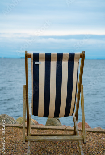 Fototapeta Naklejka Na Ścianę i Meble -  Classic deck chair on the beach by the sea, empty with no people.
