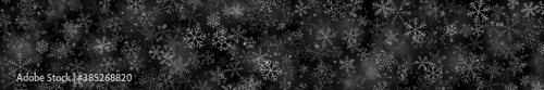 Christmas banner of snowflakes of different shapes, sizes and transparency on black background