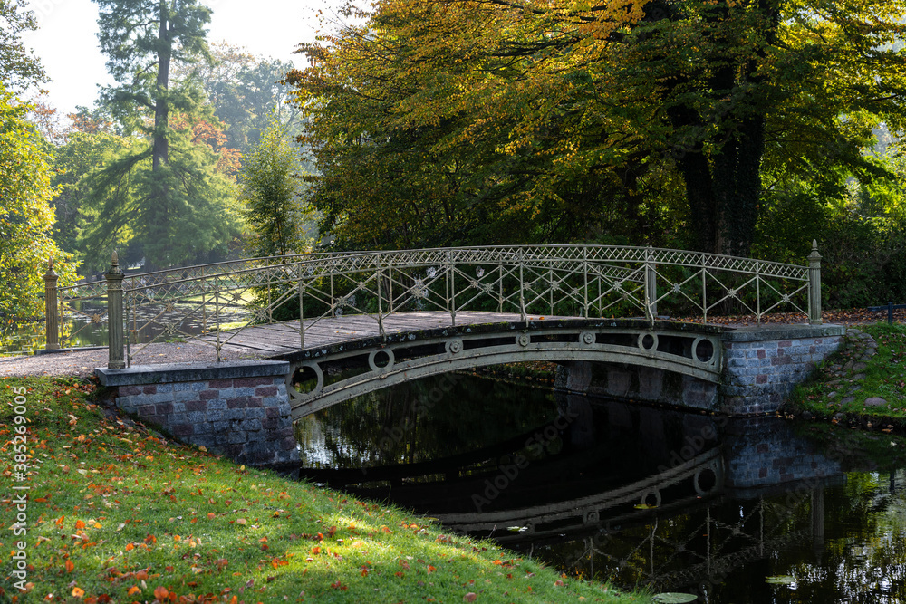 Pedestrian bridge over a canal in the park at the Schwerin castle on a sunny autumn day, copy space, selected focus