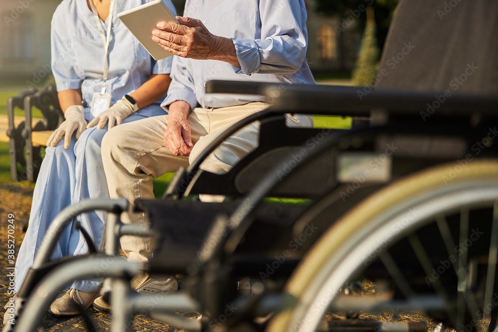 Obraz premium Image of wheelchair in front of elderly man and woman medicine worker