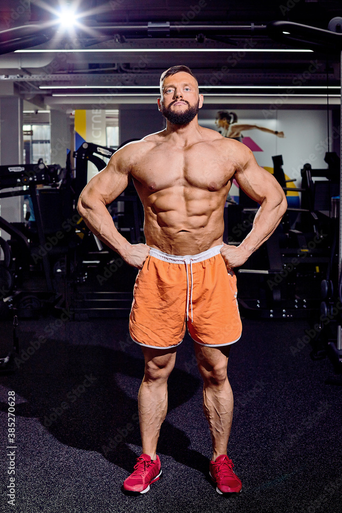 Handsome male bodybuilder in gym. Big strong man during training in the gym. Guy with big muscles who is an athlete, trainer or instructor Handsome male bodybuilder in gym. Big strong man during training in the gym. Guy with big muscles who is an athlete, trainer or instructor