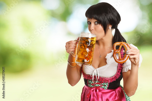 Frau im Dirndl hält Bier und Brezel
 photo